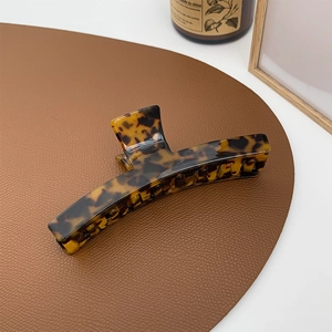 Close-up of tortoise shell pattern hair claw clip with vintage dark brown texture