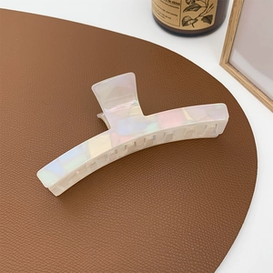 Close-up of a large iridescent hair claw clip with pearlescent finish on leather