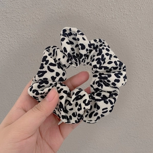 Close-up of stylish leopard print scrunchie with soft fabric texture and elastic fold