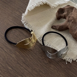 Élastiques à cheveux en métal brossé minimalistes or et argent sur bois sombre