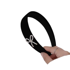 Elegant wide black velvet headband featuring a decorative white pearl bow for women