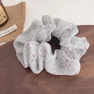 Detailed macro view of the floral scrunchie on a dark wood tray with vintage decor