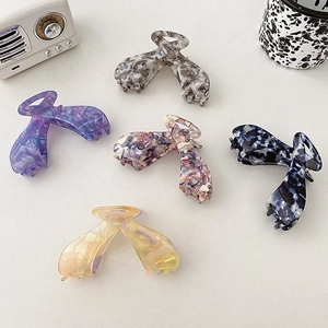 Detail showing five assorted large acetate hair claws in various elegant patterns and colors