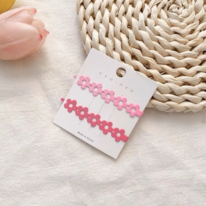 Detail von zwei matten Blumen-Haarspangen in Rosa und Rosé auf weißer Karte