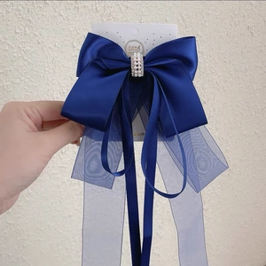 Détail d'une pince à cheveux à nœud bleu marine avec perles et strass