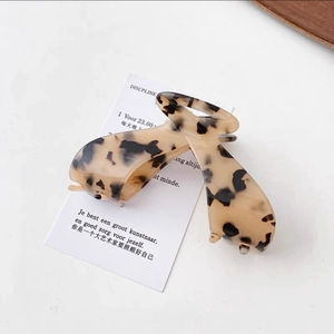 Detailed close-up of large acetate hair claw clip with tortoise leopard pattern texture