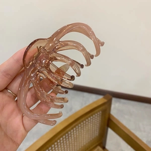 Large French style amber jelly hair claw clip for thick hair shown in a hand