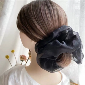 Gros plan sur un grand chouchou noir en mesh avec une texture élégante en organza
