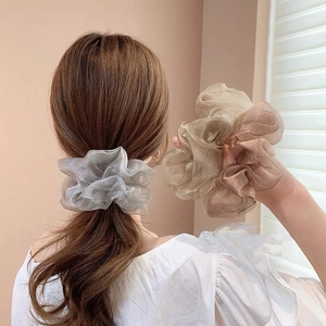 Gros plan de chouchous géants en organza translucide aux tons métallisés chic