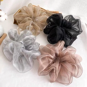 Gros plan de quatre chouchous géants en organza en champagne, noir, argent et rose fané