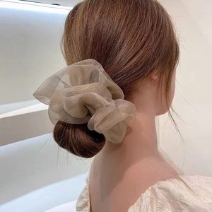 Modèle portant un chouchou en tulle champagne sur un chignon pour un look élégant