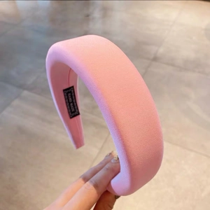 Detail of pink sponge headband featuring a handmade label on the fabric inner lining