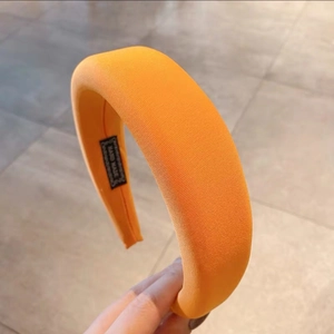 Macro detail of thick orange padded headband with handmade label and knit texture
