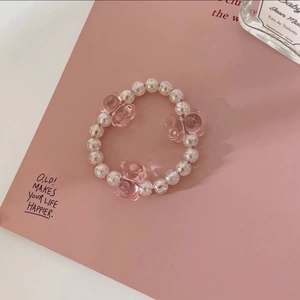 Détails des perles roses et des breloques ours sur un bracelet élastique pour les cheveux