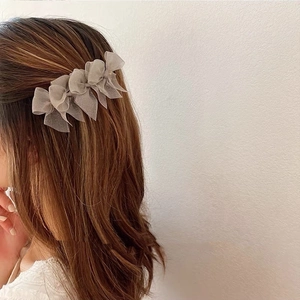 Three grey chiffon bow hair clips worn on brown hair side for an elegant look