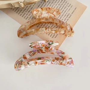 Elegantes pinzas para el cabello de acetato de carey y flores sobre libro vintage