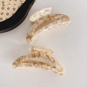 Vista detallada de pinzas para el cabello grandes de acetato con elegantes mármoles