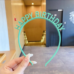 Détail d'un serre-tête d'anniversaire vert menthe avec lettres et dents antidérapantes