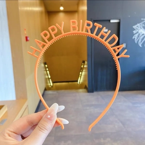 Détail d'un serre-tête orange Happy Birthday avec dents de peigne antidérapantes