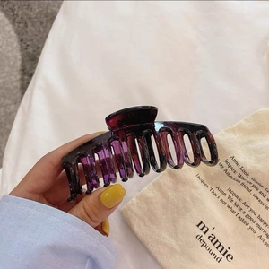Gros plan d'une grande pince à cheveux violette en acrylique translucide pour chignon
