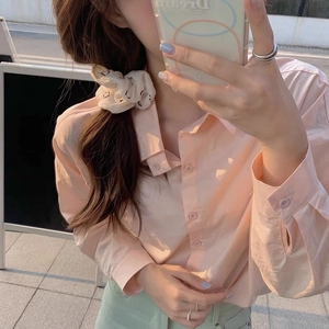 Détail de chemise en coton pêche doux avec col boutonné et manches longues décontractées