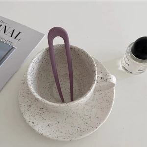 Close-up of matte lilac U-shaped hair pin in a minimalist aesthetic lifestyle setting