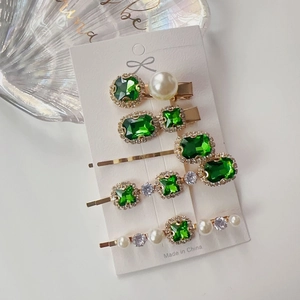 Detail of 5-piece emerald rhinestone hair clip set with faux pearls and gold plating