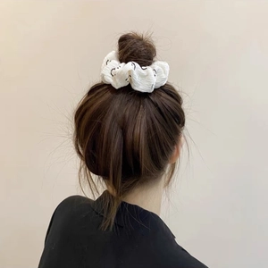 Chouchou blanc bouffant à motif visage souriant porté sur un chignon de style français