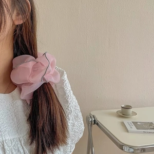 Pink organza scrunchie with silver piping shown on dark brown hair in a French style