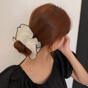 French style oversized cream organza scrunchie with black trim on low bun hairstyle