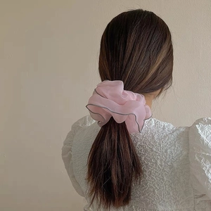 Chic pink organza scrunchie with silver piping shown on a low ponytail with casual style