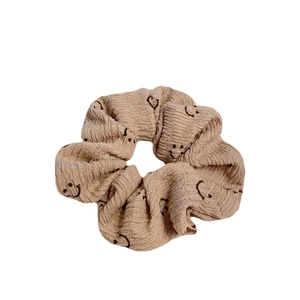 Chouchou en coton beige avec motifs sourires noirs pour une coiffure élégante