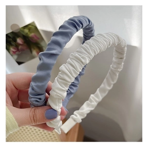 Detail of blue and ivory pleated fabric headbands showing soft ruffled texture