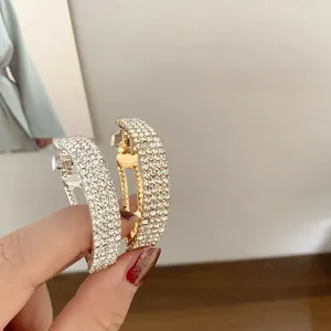 Nahaufnahme von gewölbten Strass-Haarspangen in Gold und Silber mit festem Metallclip