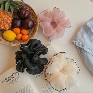 Detail of large organza hair scrunchies with contrast stitching and mesh texture