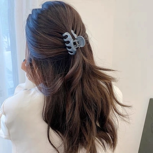 Detail of matte Morandi blue hair claw clip worn by a model for a French-style updo