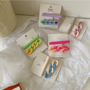 Detail of candy-colored hair clips set featuring chain design and matte finish