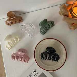 Close-up of elegant small claw clips in multiple colors like brown, green, and cream