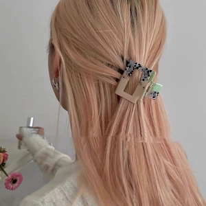 Rectangle acetate hair claw clip with floral pattern used on long pink hair