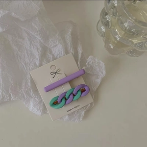 Detail of candy color purple and mint green chain hair clips on a display card