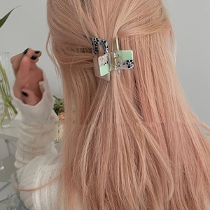 Rear view of a rectangular leopard print hair claw clip on pink blonde hair