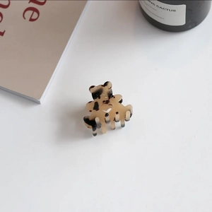 Detail of a brown tortoiseshell acetate hair claw clip in a cute hollow heart bear shape