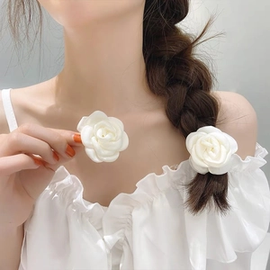 White fabric camellia hair tie and clip set on a model with elegant french style