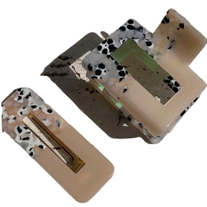 Pink and green leopard print hair claw set with rectangular clips on grey stone base
