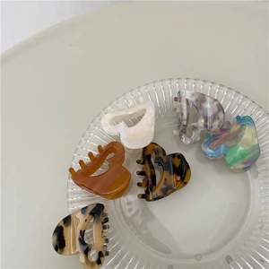 Elegant heart-shaped acetate hair claw clips in various marbled colors and patterns