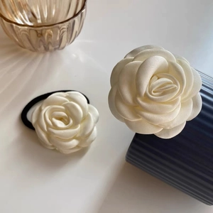 Detail of a creamy white camellia hair scrunchie with elegant silk satin flower petals