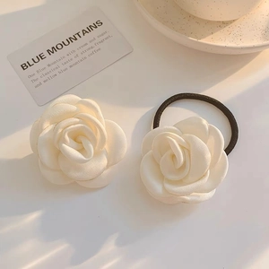 Elegant French ivory camellia hair clip and elastic hair tie set on a sunny white table
