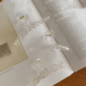 Détail macro d'une pince à cheveux transparente au fini laser avec ressort en métal