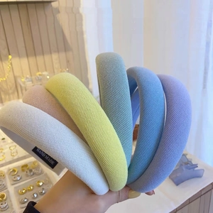 Nahaufnahme von gepolsterten Stoffstirnbändern in Makaron-Farben mit Handmade-Etiketten