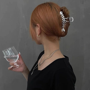 Silver metallic fishbone hair claw clip shown on a high bun with a mirror polish finish